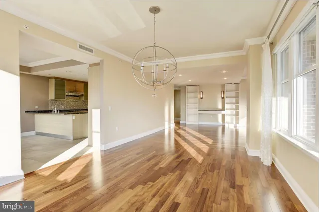 a view of a hallway view with wooden floor and a kitchen