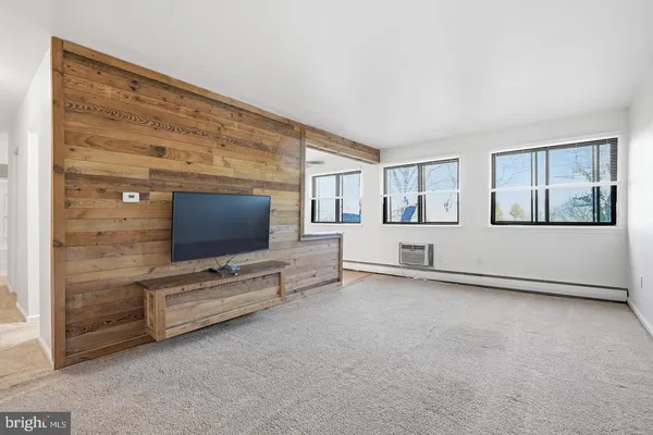 a view of an empty room with furniture and window