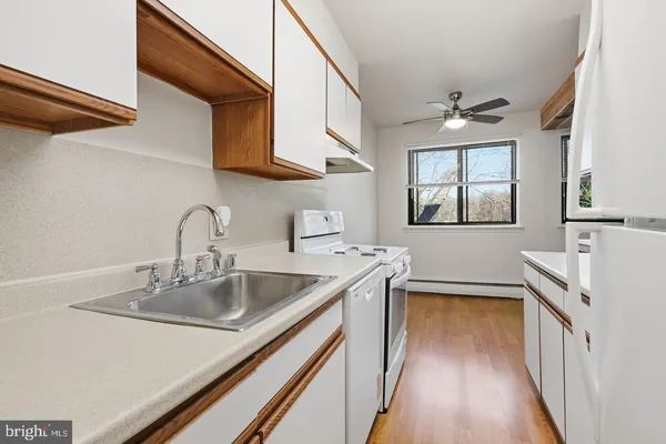 a kitchen with stainless steel appliances a sink dishwasher stove and wooden cabinets