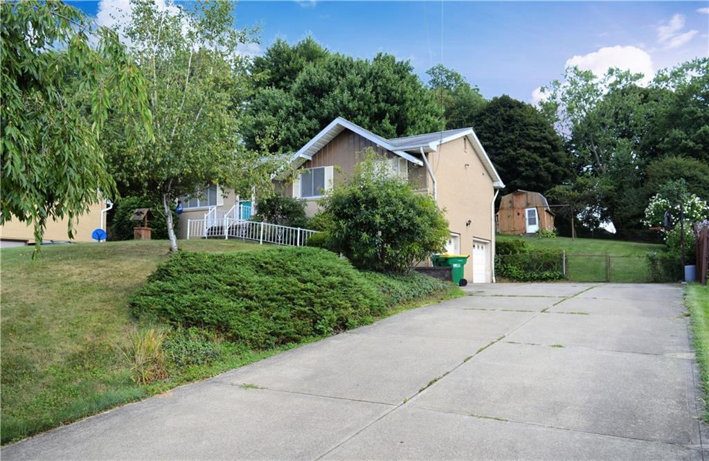 a front view of a house with a yard and trees