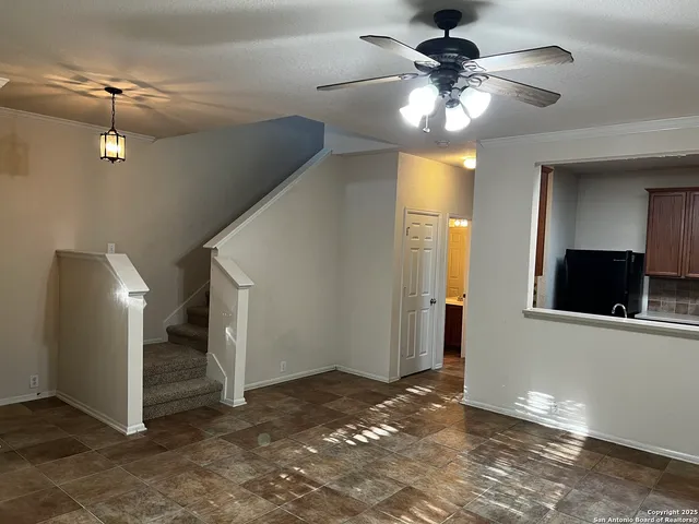 a view of a livingroom with a chandelier fan and a kitchen