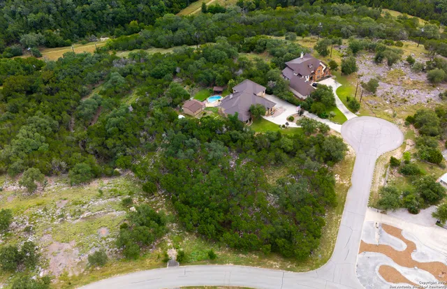 an aerial view of a house with a yard and lake view
