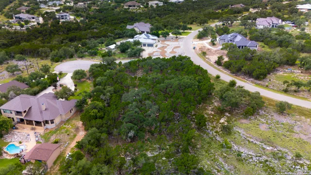 an aerial view of residential house with outdoor space and trees all around