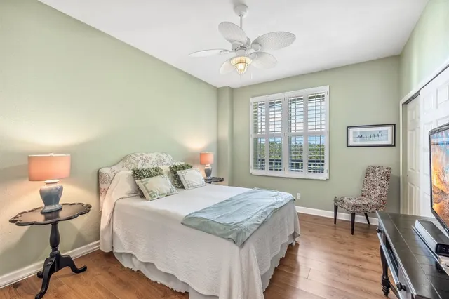 a bedroom with a bed and a table in it with window