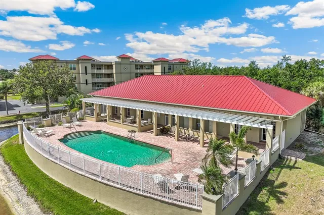 a front view of a building with garden and houses