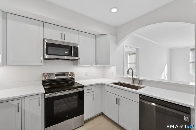 a kitchen with cabinets stainless steel appliances a sink and a counter top space