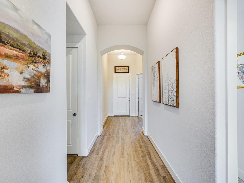 8409 Prairie Rye Drive Lago Vista, TX 78645 - Photo 6 of 17 a view of a hallway with wooden floor and a bathroom