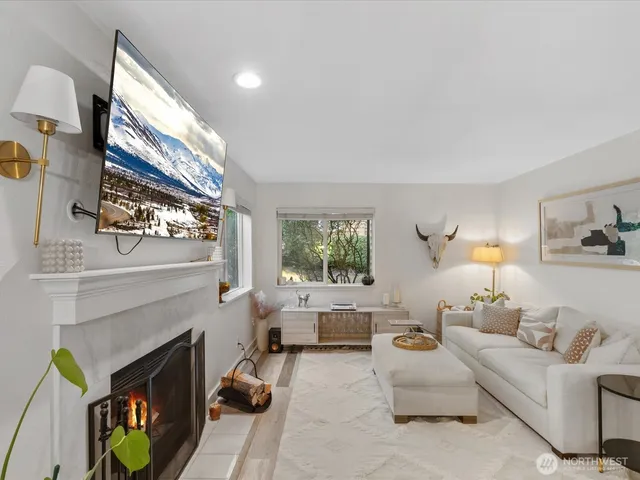 a living room with furniture a fireplace and a large window