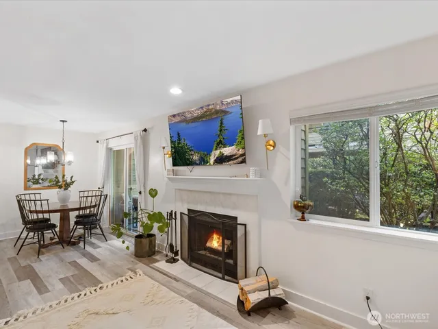 a living room with furniture a fireplace and a floor to ceiling window