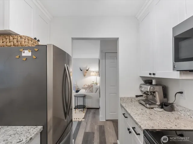 a kitchen with granite countertop a refrigerator and a sink