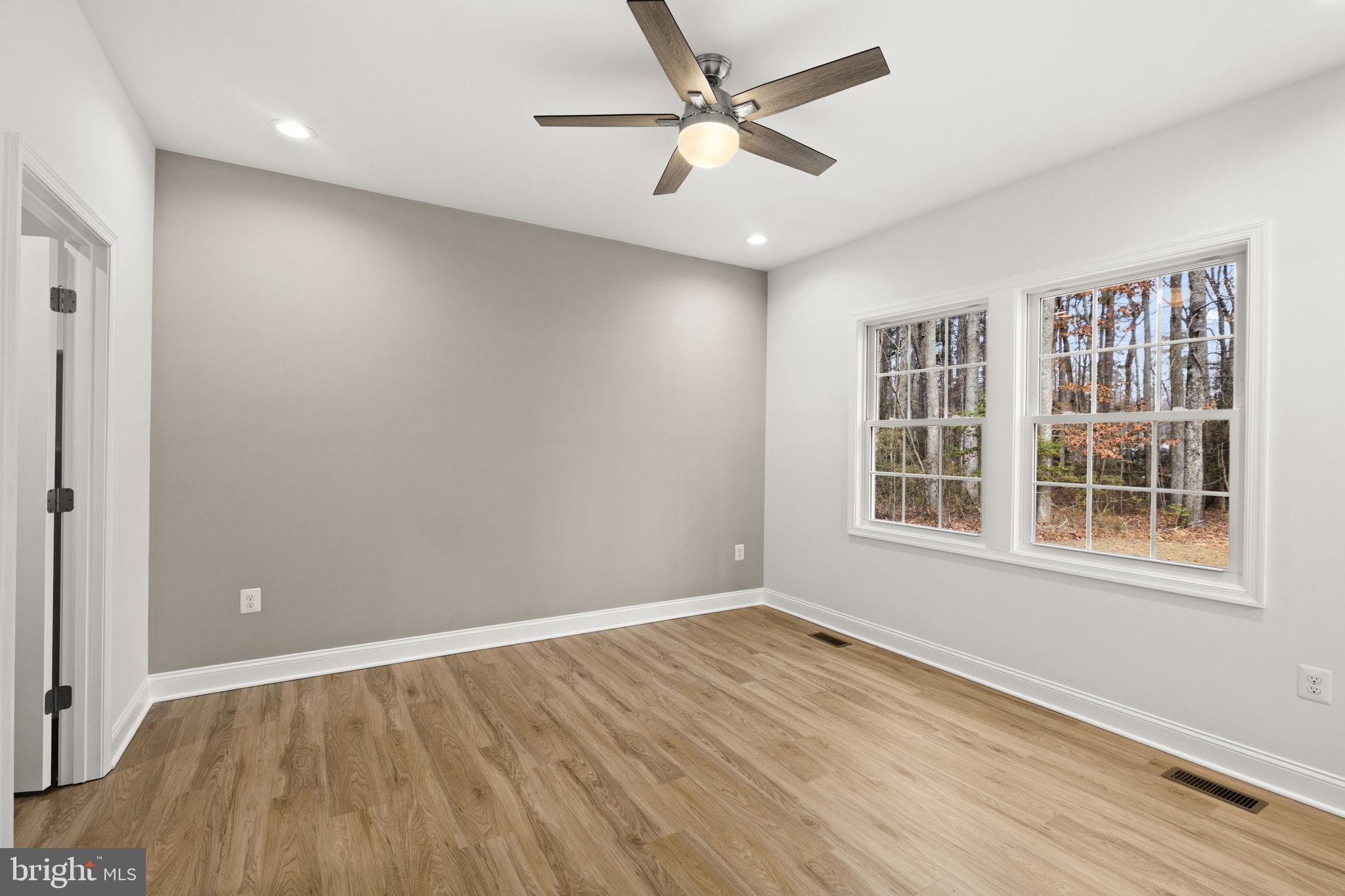27 Colony Way Montross, VA 22520 - Photo 21 of 90 an empty room with wooden floor and windows