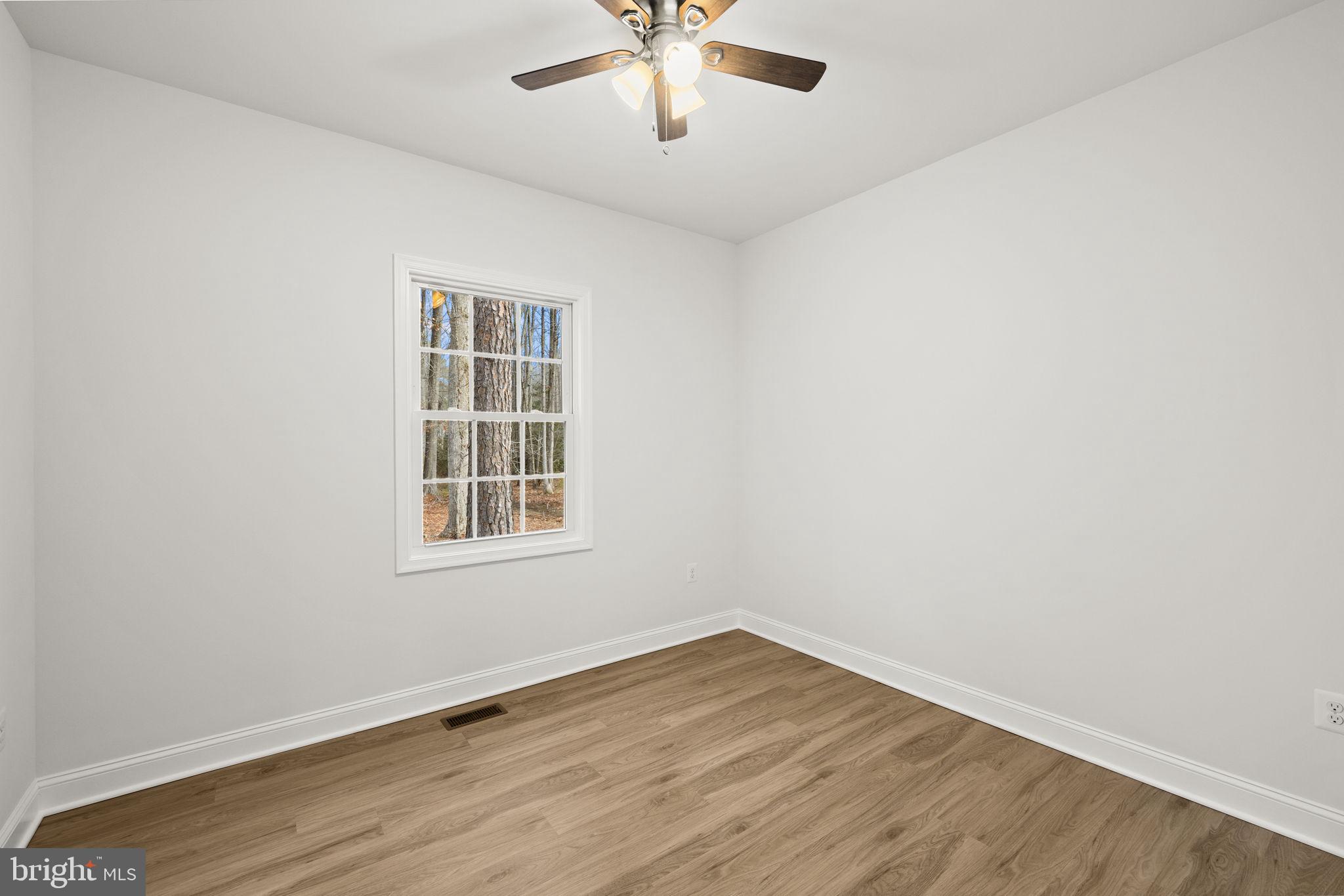 27 Colony Way Montross, VA 22520 - Photo 26 of 90 an empty room with wooden floor chandelier fan and windows