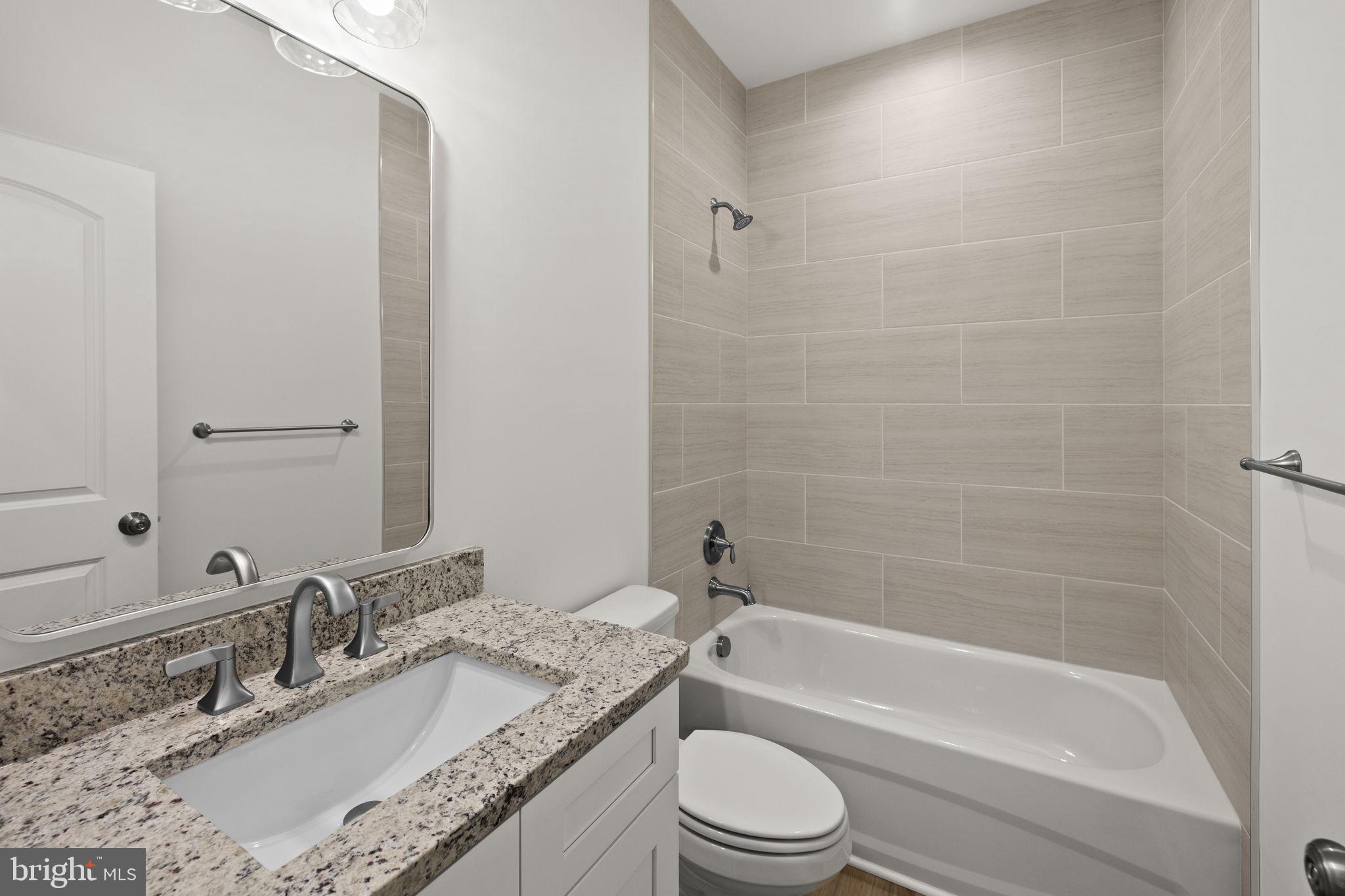 27 Colony Way Montross, VA 22520 - Photo 28 of 90 a bathroom with a granite countertop bathtub shower sink vanity mirror and toilet