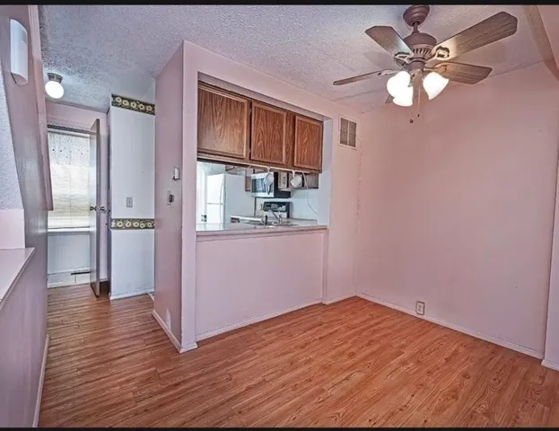 a view of an empty room with window and wooden floor