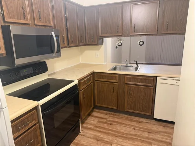 a kitchen with stainless steel appliances a stove a sink and a microwave