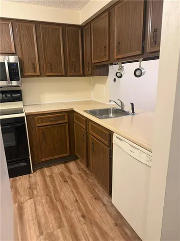 a kitchen with a sink a stove cabinets and utility