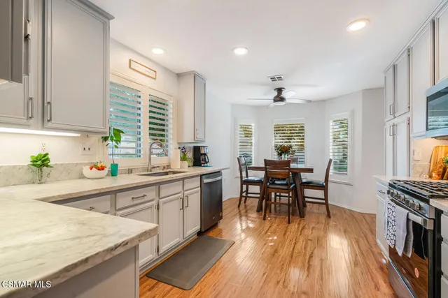 a kitchen with stainless steel appliances granite countertop sink stove top oven and cabinets