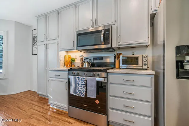 a kitchen with stainless steel appliances granite countertop a stove and a microwave