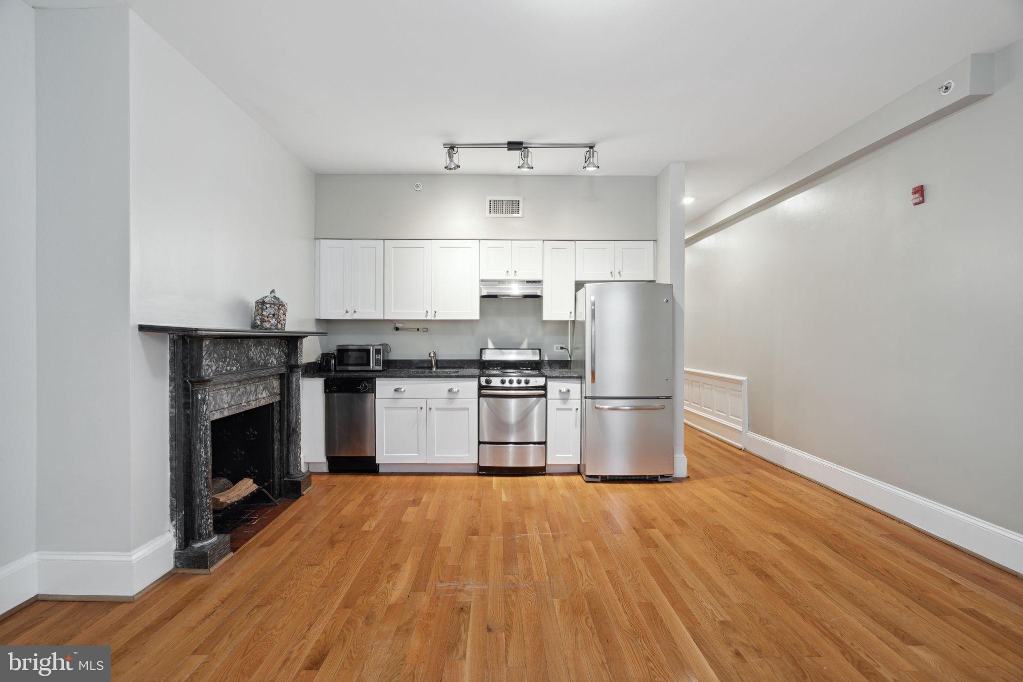 1955 Locust Street, Unit 2R Philadelphia, PA 19103 - Photo 6 of 19 a kitchen with a sink wooden floor and stainless steel appliances