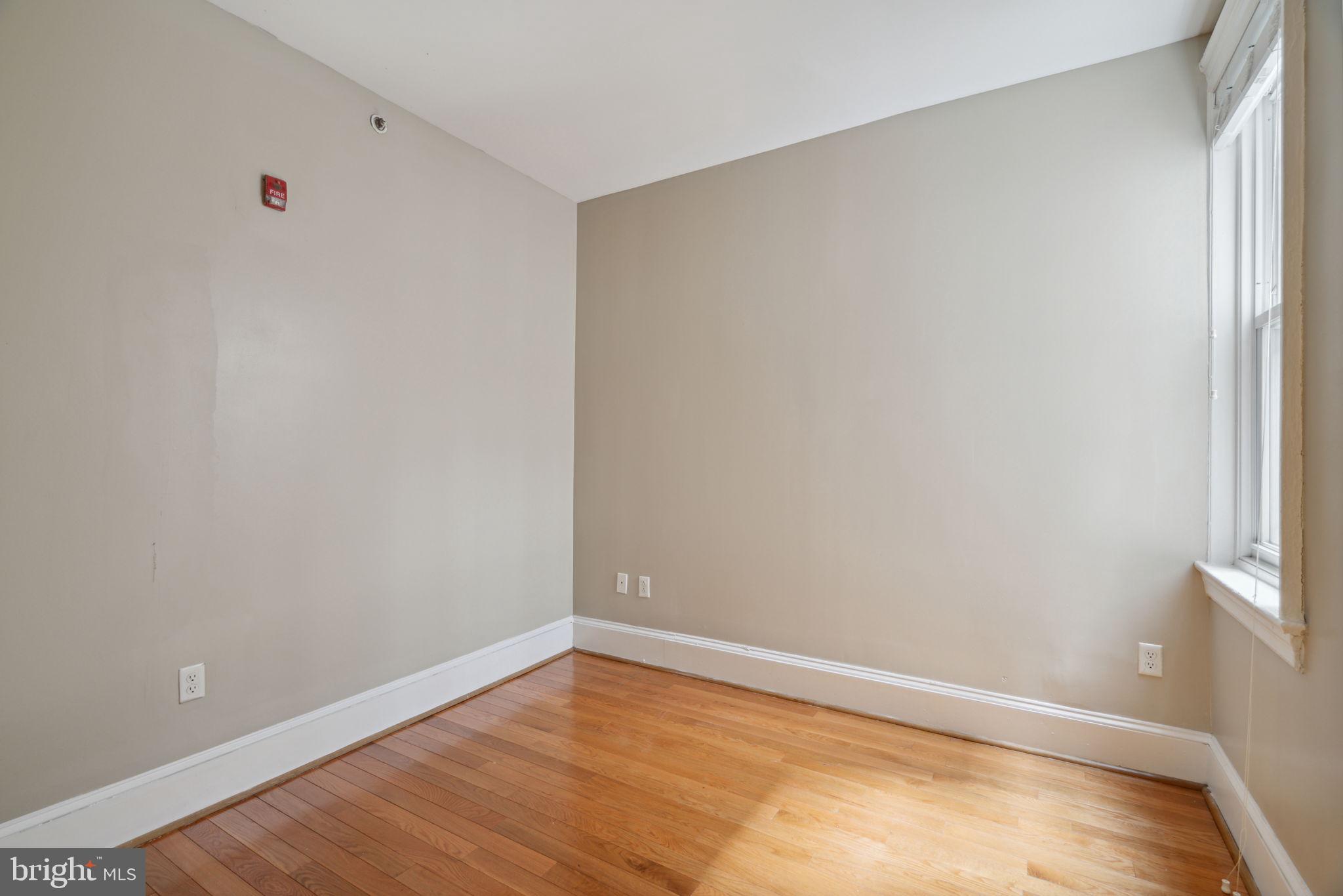 1955 Locust Street, Unit 2R Philadelphia, PA 19103 - Photo 8 of 19 a view of an empty room with wooden floor and a window