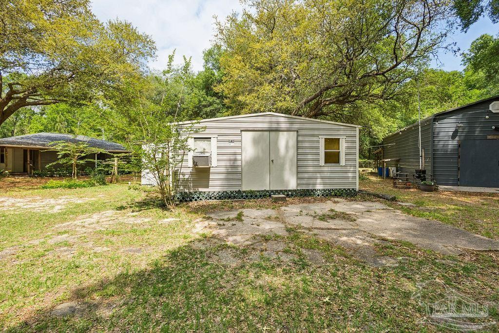 8938 Pioneer Road Holt, FL 32564 - Photo 33 of 44 a view of a house with a backyard