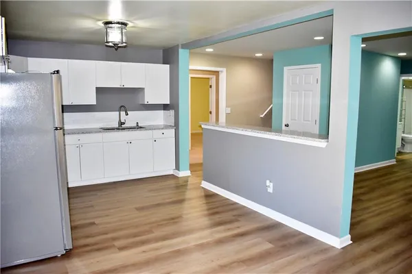 a large kitchen with a wooden floor and cabinets