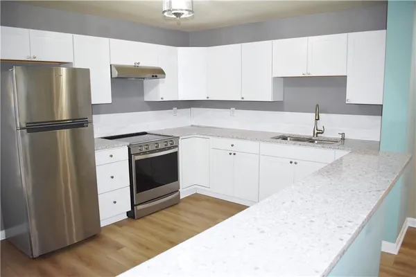 a kitchen with a sink a refrigerator and a stove top oven