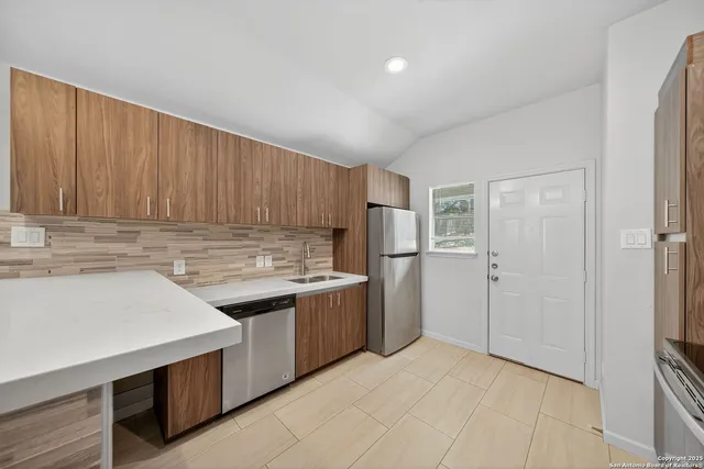 a kitchen with stainless steel appliances granite countertop a refrigerator and a sink
