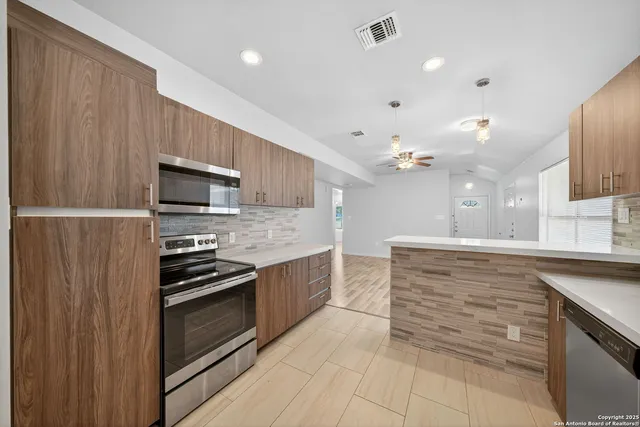 a large kitchen with granite countertop a stove and a sink