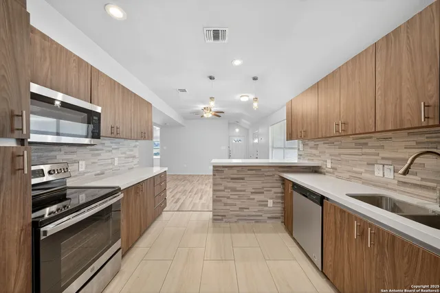 a kitchen with stainless steel appliances granite countertop a sink stove and microwave