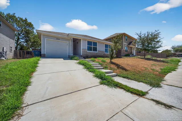 a front view of a house with a yard and a garage