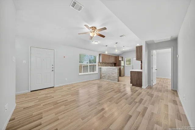 a view of a big room with wooden floor and a ceiling fan