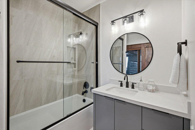 7885 North Rabbitbrush Court, Unit 13 Park City, UT 84098 - Photo 51 of 88 Bathroom featuring a tub/shower combination with glass enclosure and light-toned wall tiling