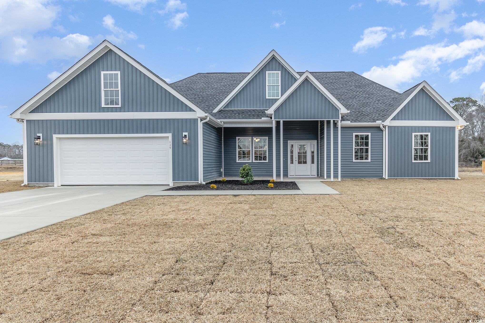 View of front of property with a shingled roof, driveway, a porch, and a front lawn