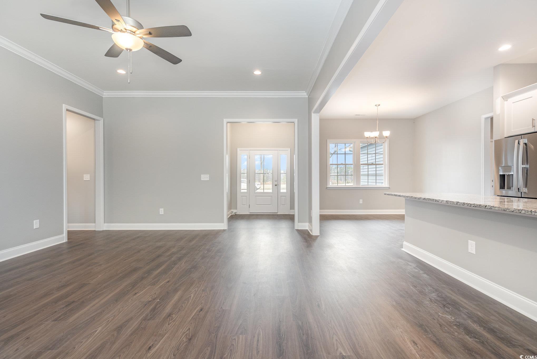 2104 Highway 9 Business Loris, SC 29569 - Photo 6 of 20 Unfurnished living room featuring dark wood finished floors, crown molding, recessed lighting, a ceiling fan, and a chandelier