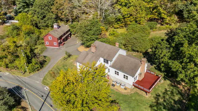 an aerial view of a house with swimming pool and red chairs