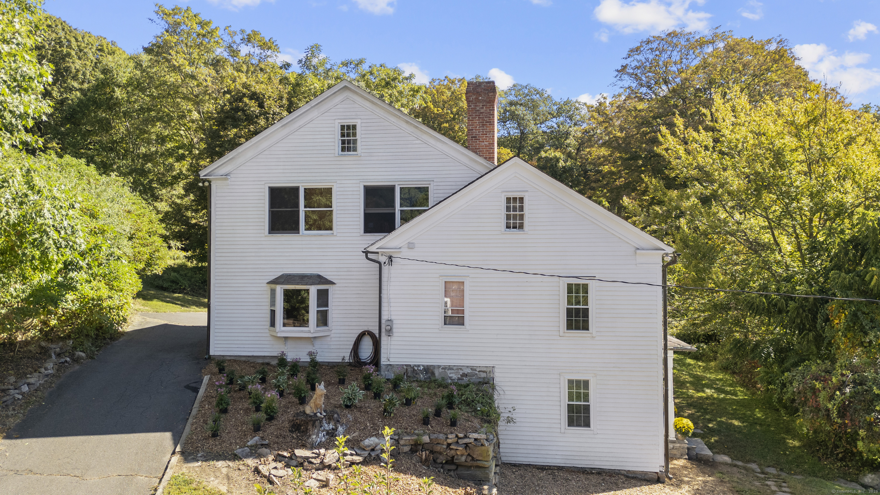 62 Codfish Hill Road Bethel, CT 06801 - Photo 5 of 25 a view of a white house next to a yard with large trees