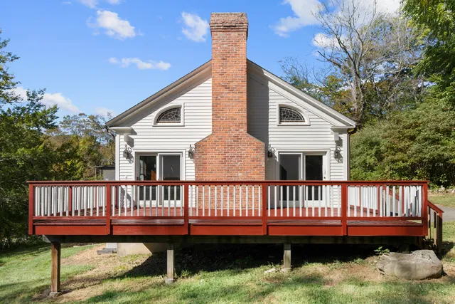a view of a house with a wooden deck and a yard