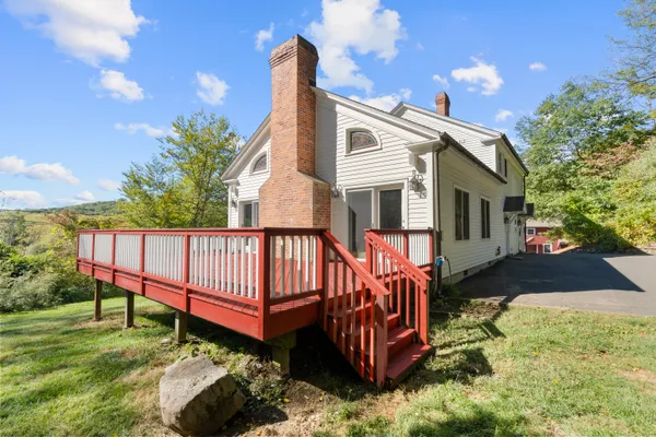 a view of a house with wooden deck and a yard