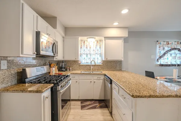 a kitchen with a sink stove and cabinets