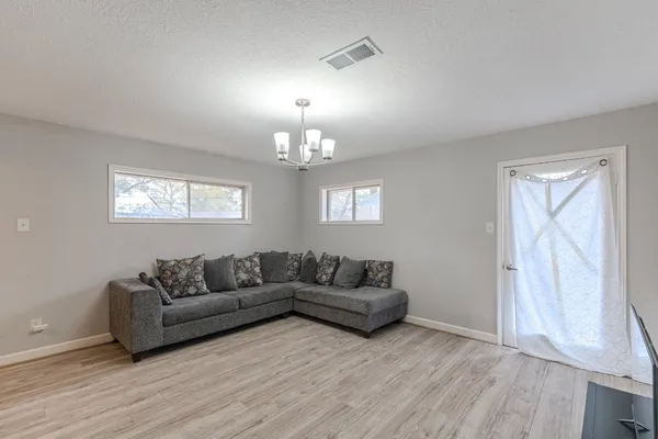 a living room with furniture and a chandelier