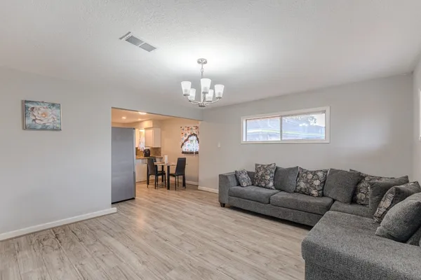 a living room with furniture and a chandelier