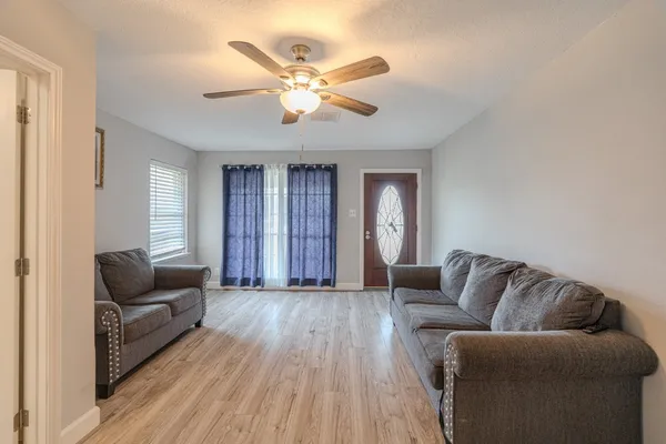 a living room with furniture and wooden floor