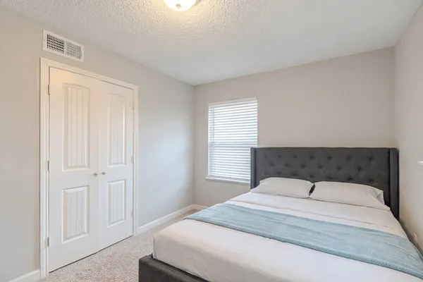 a bedroom with a bed and a window