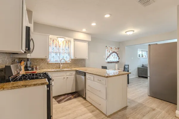 a kitchen with stainless steel appliances granite countertop a sink stove and refrigerator