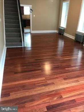 a view of hallway with stairs and wooden floor