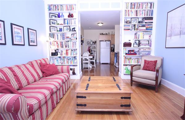 a living room with furniture and a book shelf