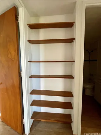 a view of walk in closet with empty racks