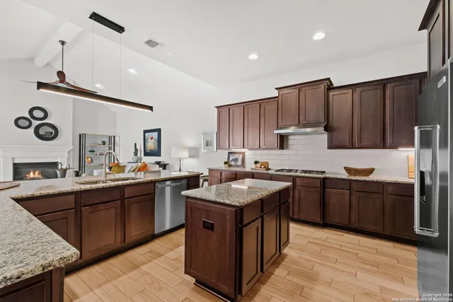 a kitchen with kitchen island granite countertop a sink stove and refrigerator