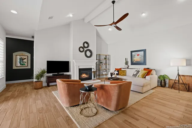 a living room with furniture a flat screen tv and a fireplace